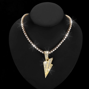 Close-up of golden lightning bolt pendant with full diamond pavé on a black display stand