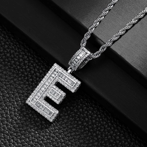 Macro detail of iced-out hip hop letter E pendant with baguette diamonds on rope chain