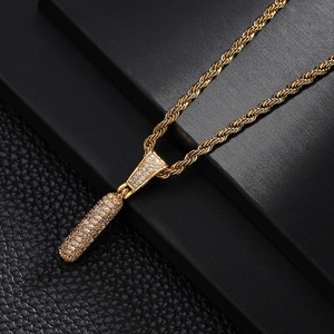 Close-up of gold iced-out capsule pendant with crystals on a thick rope chain