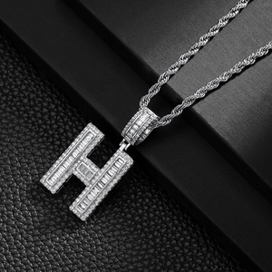 Close-up of hip hop silver H letter pendant with sparkling stones on rope chain
