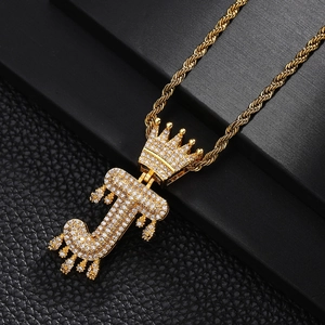 Détail macro du collier pendentif lettre J couronne dorée avec micro-pavage de zircone cubique