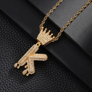 Vue macro du pendentif couronne lettre K en plaqué or avec zircons cubiques brillants