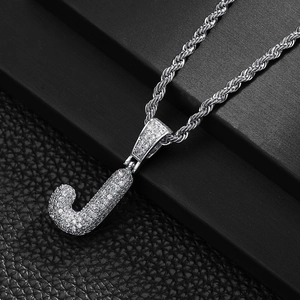 Macro detail of silver letter J pendant with micro-pave zircons on a rope chain