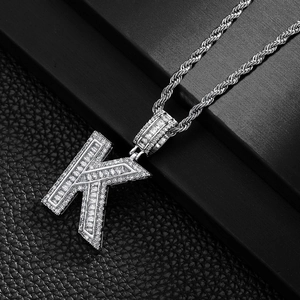 Detail of hip hop K-letter pendant with baguette zircon inlay on silver rope chain