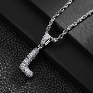 Macro detail of iced-out letter L pendant with zircon stones and rope chain