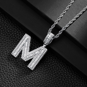 Close-up of hip hop square letter M pendant with baguette-cut and micro-pave crystals