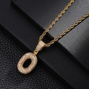 Macro shot of gold-plated letter O pendant with cubic zirconia and twisted rope chain