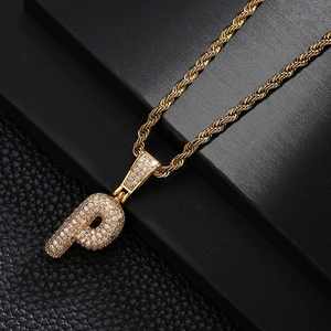 Detail of gold-plated rope chain necklace with a zircon-encrusted letter P pendant