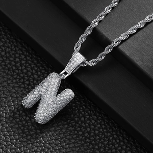 Macro shot of silver hip-hop letter N pendant with pavé zircon on a rope chain