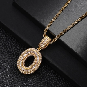 Macro shot of gold letter O pendant with pavé cubic zirconia on a black leather stand