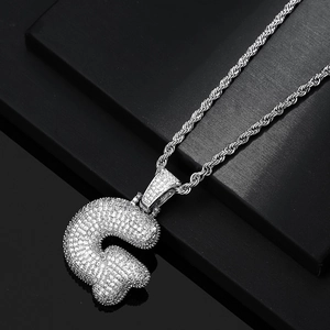 Macro shot of hip hop bubble letter G pendant with cubic zirconia and silver rope chain