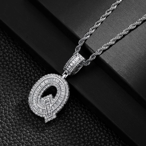 Macro shot of silver hip hop Q letter pendant with micro-pave zircons and rope chain