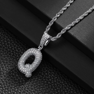 Macro shot of silver bubble letter Q pendant with micro-pave cubic zirconia on rope chain