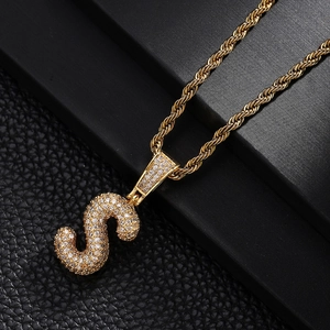 Close-up of golden letter S pendant necklace with shimmering cubic zirconia micro-pave