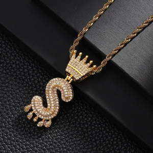 Gros plan du pendentif couronne lettre S dorée hip hop serti de zircons