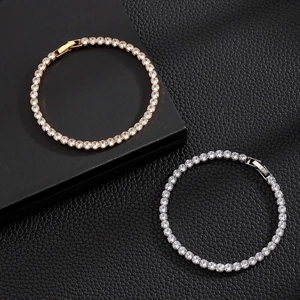 Close-up of gold and silver tennis bracelets with zircon stones in four-prong settings