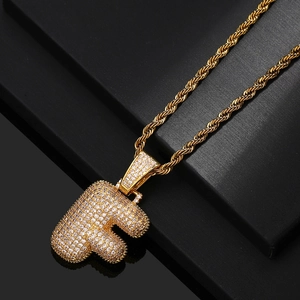 Macro shot of gold-plated letter F pendant with pavé cubic zirconia and rope chain