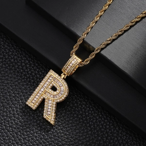 Macro shot of gold plated hip hop letter R pendant with cubic zirconia on rope chain