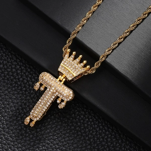 Vue détaillée du pendentif couronne plaqué or avec lettre T et zircons étincelants