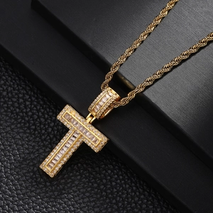 Macro view of gold plated cross pendant with cubic zirconia on black leather