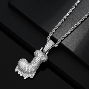 Dettaglio macro del ciondolo lettera J ghiacciato con zirconi su catena a maglia argento