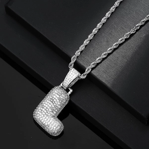 Detailed macro view of iced-out bubble letter J pendant with silver rope chain