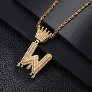 Macro d'un collier hip-hop doré avec pendentif lettre W et design couronne drip