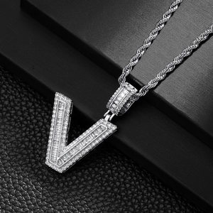 Close-up of hip hop silver V-pendant necklace with baguette and round cubic zirconia stones