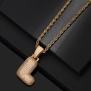 Close-up of golden letter L pendant with pavé cubic zirconia on a rope chain