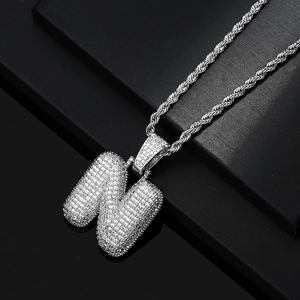 Detailed view of silver bubble letter N pendant with iced out cubic zirconia and rope chain