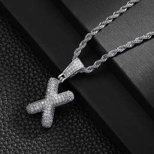Close-up of hip hop letter X pendant with shiny zircon stones on silver rope chain