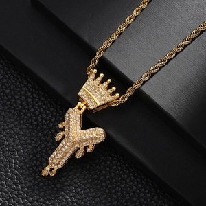 Vue macro du pendentif couronne lettre Y doré avec zircons pavés sur chaîne corde