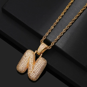 Macro shot of gold-plated twisted rope chain with iced out letter N zircon pendant
