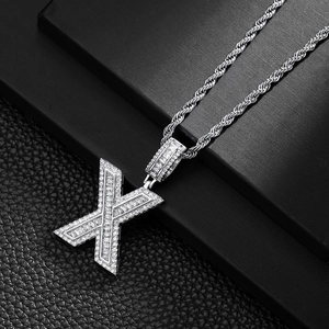 Detail of hip-hop silver X pendant with baguette cubic zirconia on a thick rope chain