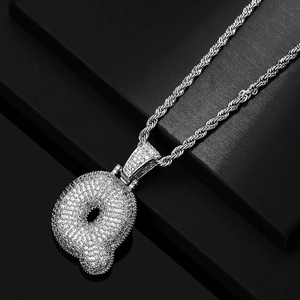Macro shot of silver hip hop bubble letter Q pendant encrusted with clear cubic zirconia