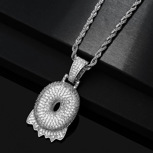 Macro del ciondolo a ciambella argentato con zirconi brillanti su una catena a fune