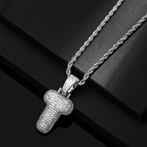 Macro detail of iced-out silver letter T pendant with zircon on a sturdy rope chain