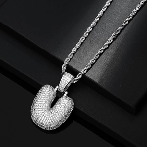 Macro shot of silver hip hop U-letter pendant with pavé cubic zirconia and rope chain
