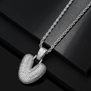 Macro view of iced out heart pendant with white zircons and silver rope chain