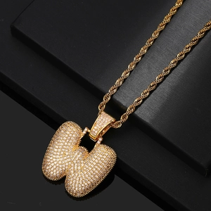 Close-up of gold-plated bubble letter W pendant with micro-pave zircons and rope chain
