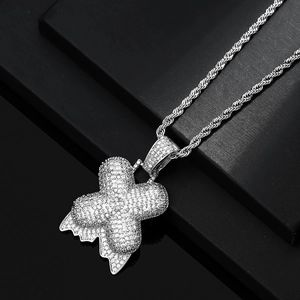 Dettaglio del ciondolo a lettera X in argento con zirconi e catena a corda stile hip-hop