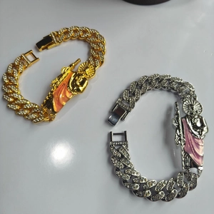 Detail of hip hop Cuban link bracelets with iced out St. Jude charm and colorful enamel