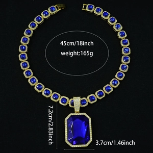 Detailed view of luxury hip-hop necklace with large blue gemstone and gold Cuban chain links