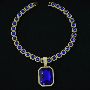 Close-up of hip hop cuban chain with square emerald-cut blue gemstone pendant in gold