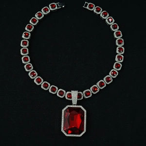 Macro shot of luxury Cuban link necklace with rectangular ruby pendant and pave diamonds