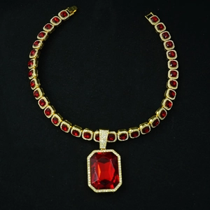 Macro shot of hip-hop gold necklace with square red gemstones and emerald-cut ruby pendant