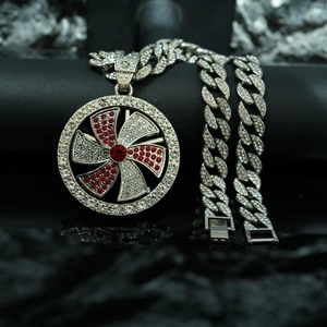 Detalle del colgante giratorio con cristales rojos y blancos y cadena cubana con diamantes