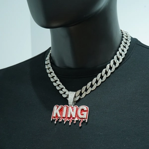 Dettaglio della collana cubana hip hop con ciondolo KING ghiacciato e design a goccia rossa