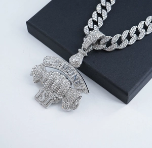 Macro shot of silver hip hop necklace with iced out GET MONEY 1ST pendant and bag charm
