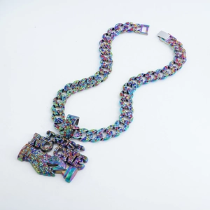 Dettaglio del ciondolo TRUST NO ONE colorato con strass scintillanti su catena hip hop